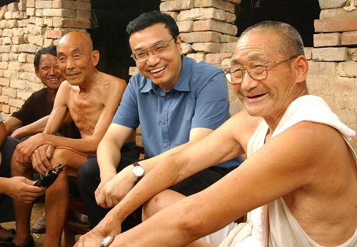 2003年8月8日,时任省委书记的李克强在河南新乡调研。图为他在原阳县桥北乡马庄村与村民亲切交谈。新华社发(郭宇摄)