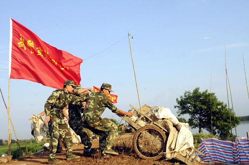 7月20日晨,武警安徽总队宣城市支队官兵在宣州区狸桥镇石马圩封堵管涌。由于长江支流水阳江水位持续增高,安徽宣城市宣州区养贤乡石马圩长时间受洪水浸泡,出现管涌、渗漏和小面积塌方。7月19日23时开始,武警安徽总队宣城市支队100名官兵奋战近11个小时,截止到20日上午9时30分,成功封堵1处直径30余公分的大管涌和6处小管涌,排除了险情。新华社发(廖福安 摄)