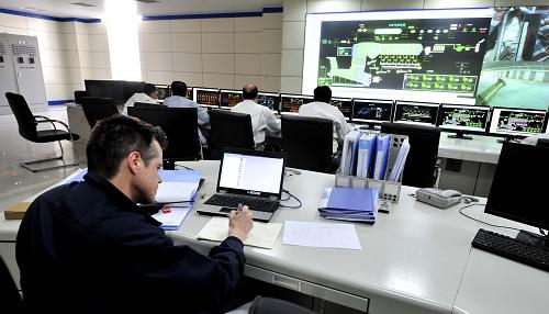 4月12日,一名外国工程技术人员和中方人员在发电厂总控室进行调试工作。为保障滨海新区汉沽垃圾焚烧发电厂按期并网发电,国家电网滨海供电分公司的建设者正在加紧进行并网发电的组塔、架线施工。据介绍,滨海新区汉沽垃圾焚烧发电厂终期规划日处理生活垃圾2000吨,年处理生活垃圾66.7万吨,年发电量为1.46亿千瓦时。目前,一期工程总投资达8.07亿元,日处理生活垃圾1500吨,年发电量为1.26亿千瓦时。发电厂内的完全密封垃圾储存池,可储存2万吨垃圾,采用国际上最先进的复式排焚烧炉焚烧工艺,烟气排放达到欧盟2000标准。新华社记者 刘海峰 摄