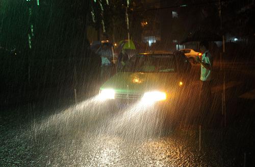 7月27日,石景山区鲁谷社区的保安在大雨中执勤。新华社记者 何俊昌 摄