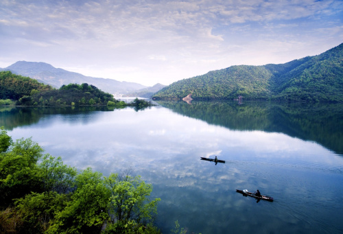 清晨，霍山县群众在佛子岭库区驾小船前行（4月9日摄）。四月，大别山腹地的安徽省霍山县一片春光明媚景色，青翠的山峦云蒸霞蔚，漫山遍野的映山红绚丽似火，处处是春的涌动。佛子岭、屋脊山、黑虎尖等大自然美景，已成为游人踏青、观花、旅游、摄影的好去处。新华社发（徐程 摄）